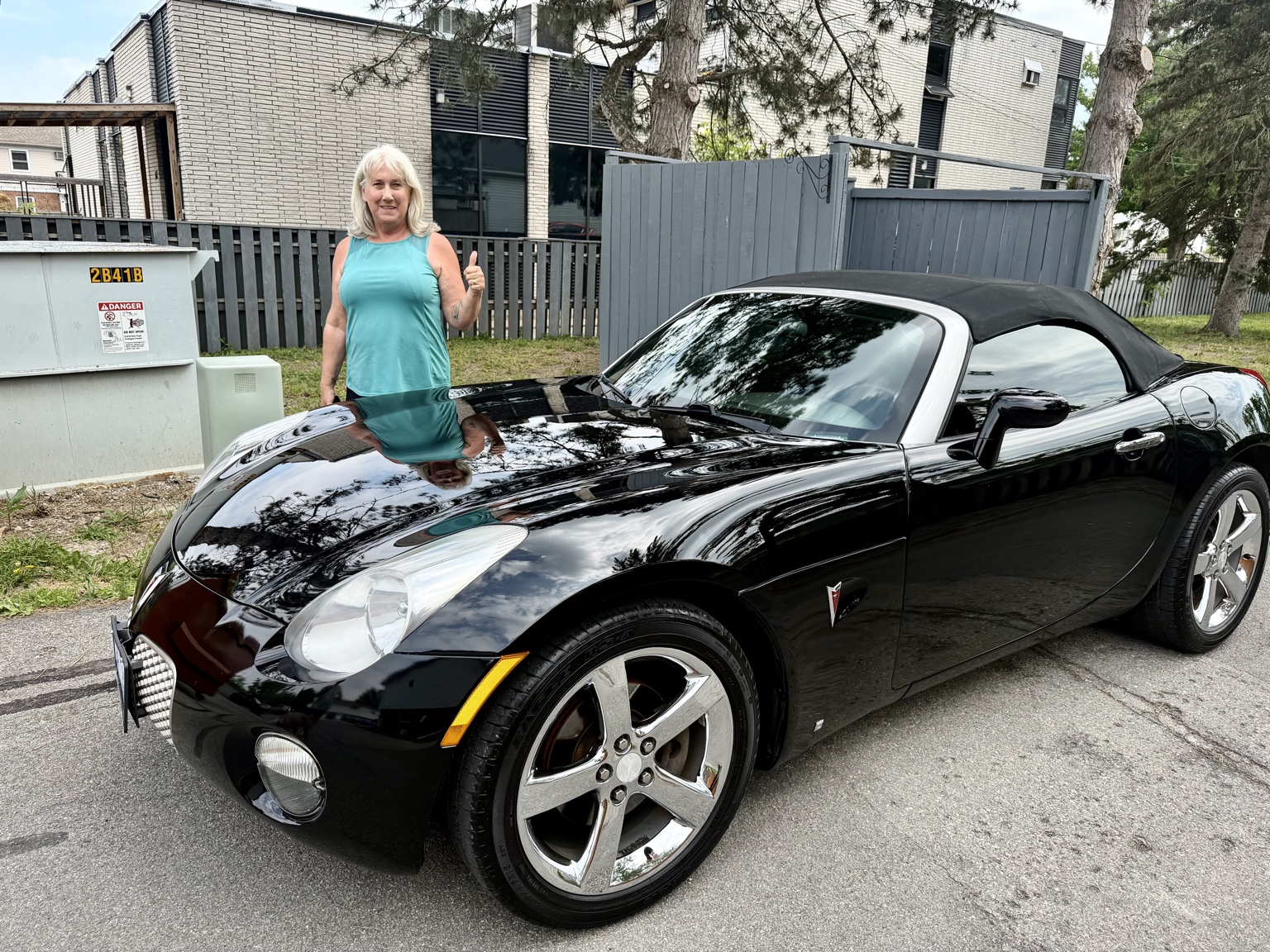Happy customer with freshly detailed black convertible