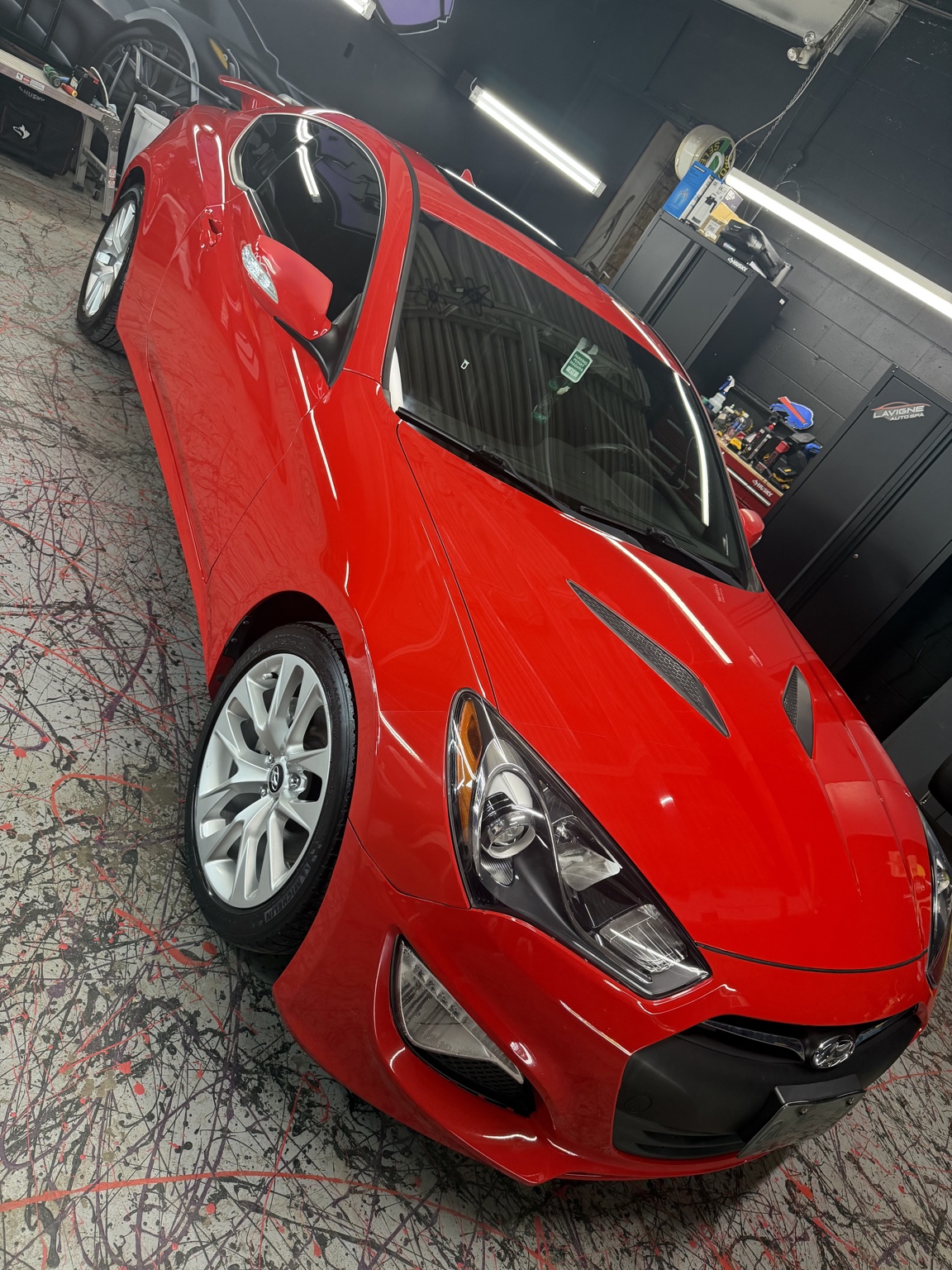 Red coupe detailed inside Lavigne Autospa shop